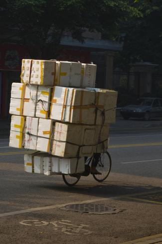 Photographic Print: Cyclist in China with huge load of boxes by Charles Bowman: 24x16in