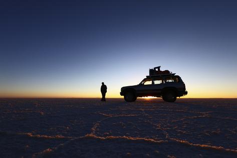 Photographic Print: Toyota Land Cruiser Silhouetted Against Sunrise, Salar De Uyuni, Bolivia by James Brunker: 24x16in