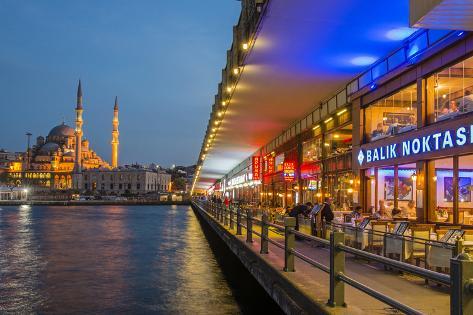 Photographic Print: Outdoor Restaurants under Galata Bridge with Yeni Cami or New Mosque at Dusk, Istanbul by Stefano Politi Markovina: 24x16in