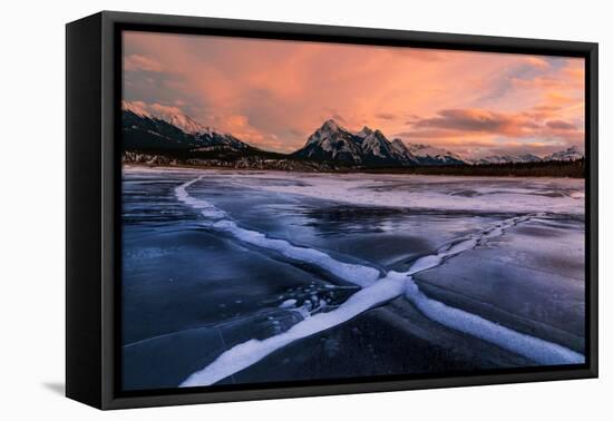 Ice cracks along Abraham Lake in Banff, Canada at sunset with pink clouds and scenic mountains-David Chang-Framed Premier Image Canvas