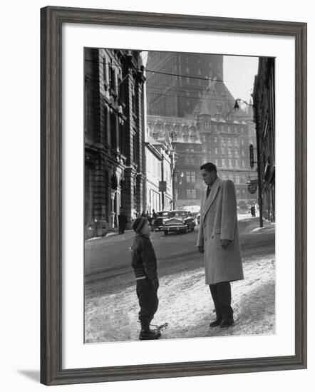 Ice Hockey Player Jean Beliveau, Standing in a Snow Covered Street Speaking to a Child-Yale Joel-Framed Premium Photographic Print