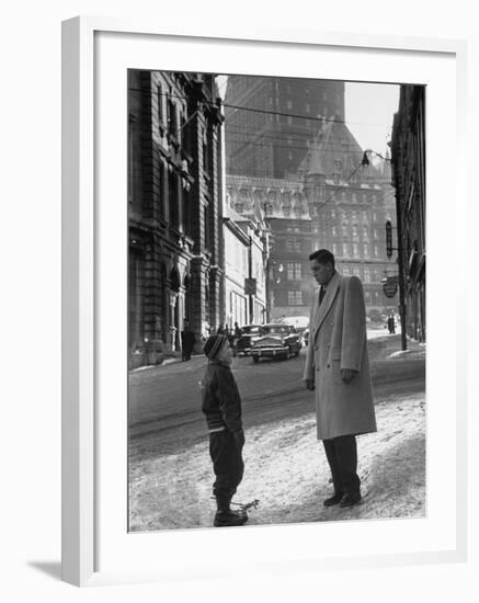 Ice Hockey Player Jean Beliveau, Standing in a Snow Covered Street Speaking to a Child-Yale Joel-Framed Premium Photographic Print