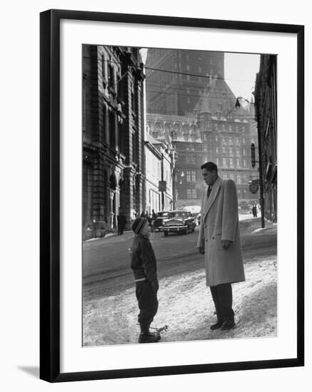Ice Hockey Player Jean Beliveau, Standing in a Snow Covered Street Speaking to a Child-Yale Joel-Framed Premium Photographic Print