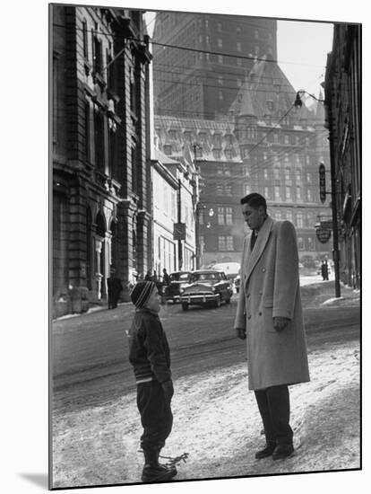 Ice Hockey Player Jean Beliveau, Standing in a Snow Covered Street Speaking to a Child-Yale Joel-Mounted Premium Photographic Print