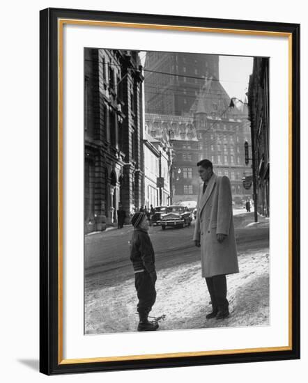 Ice Hockey Player Jean Beliveau, Standing in a Snow Covered Street Speaking to a Child-Yale Joel-Framed Premium Photographic Print