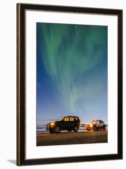 Iceland, Europe. Cars with lights on at night under a starry sky and the northern lights.-Marco Bottigelli-Framed Photographic Print