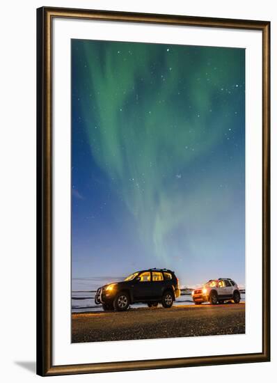 Iceland, Europe. Cars with lights on at night under a starry sky and the northern lights.-Marco Bottigelli-Framed Photographic Print