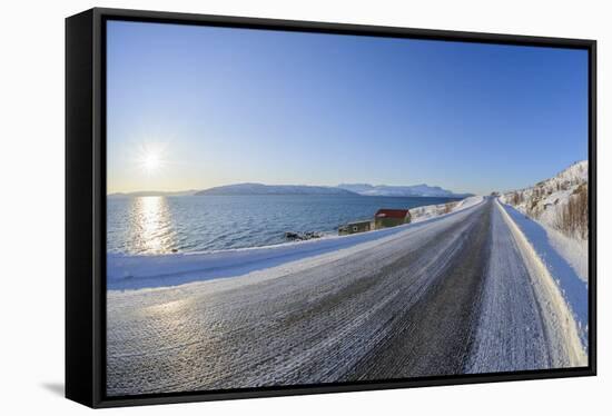 Icy coastal road with sun in winter, Buvik, Kvaloy, Troms, Norway-Raimund Linke-Framed Stretched Canvas