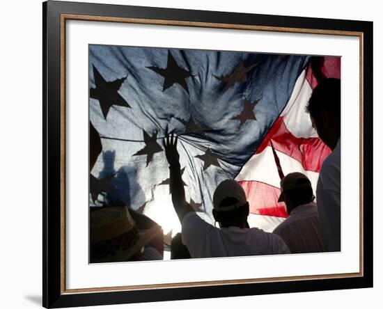 Immigration Rights Demonstrators Hold a U.S. Flag Aloft During a March Along Wilshire Boulevard-null-Framed Photographic Print