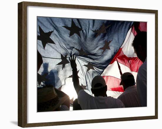 Immigration Rights Demonstrators Hold a U.S. Flag Aloft During a March Along Wilshire Boulevard-null-Framed Photographic Print