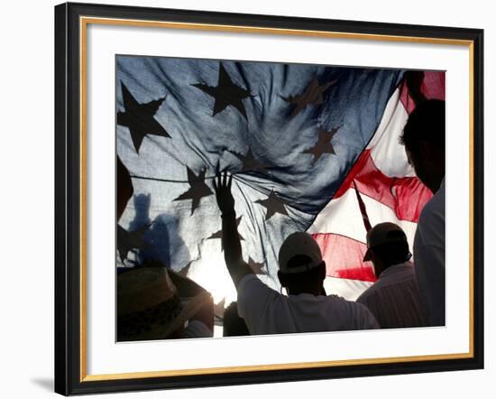 Immigration Rights Demonstrators Hold a U.S. Flag Aloft During a March Along Wilshire Boulevard-null-Framed Photographic Print