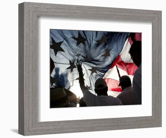 Immigration Rights Demonstrators Hold a U.S. Flag Aloft During a March Along Wilshire Boulevard-null-Framed Photographic Print