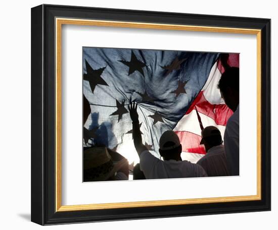 Immigration Rights Demonstrators Hold a U.S. Flag Aloft During a March Along Wilshire Boulevard-null-Framed Photographic Print