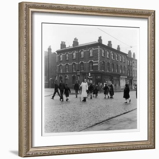 In Liverpool, a Lollipop Lady Helps Children Cross a Cobbled Street-Henry Grant-Framed Photographic Print