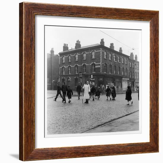 In Liverpool, a Lollipop Lady Helps Children Cross a Cobbled Street-Henry Grant-Framed Photographic Print