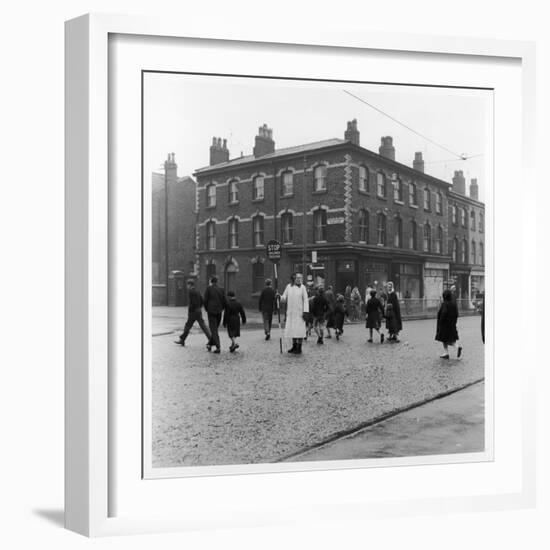 In Liverpool, a Lollipop Lady Helps Children Cross a Cobbled Street-Henry Grant-Framed Photographic Print
