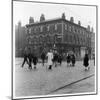 In Liverpool, a Lollipop Lady Helps Children Cross a Cobbled Street-Henry Grant-Mounted Photographic Print