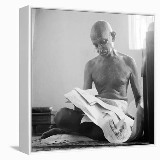 Indian Leader Mohandas Gandhi Reading as He Sits Cross Legged on Floor, at Home-Margaret Bourke-White-Framed Premier Image Canvas