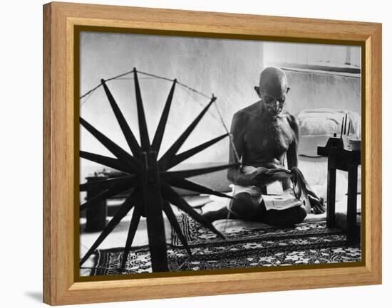 Indian Leader Mohandas Gandhi Reading as He Sits Cross Legged on Floor-Margaret Bourke-White-Framed Premier Image Canvas