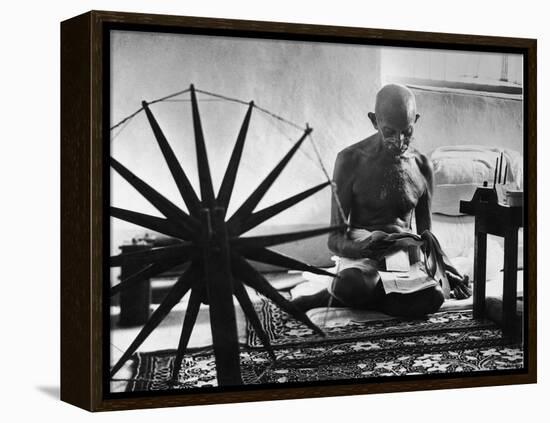 Indian Leader Mohandas Gandhi Reading as He Sits Cross Legged on Floor-Margaret Bourke-White-Framed Premier Image Canvas