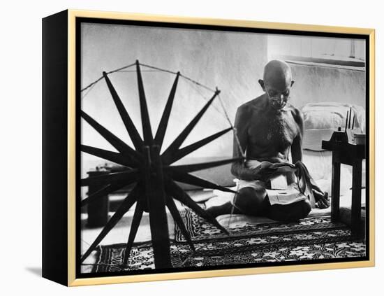 Indian Leader Mohandas Gandhi Reading as He Sits Cross Legged on Floor-Margaret Bourke-White-Framed Premier Image Canvas