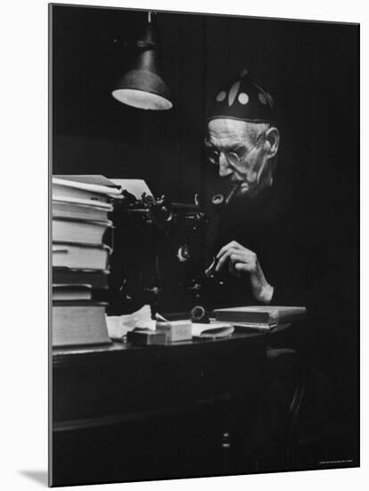 Irish Playwright Sean O'Casey with Pipe in His Mouth as He Works at His Typewriter at Home-Gjon Mili-Mounted Premium Photographic Print