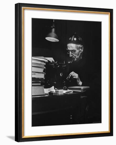 Irish Playwright Sean O'Casey with Pipe in His Mouth as He Works at His Typewriter at Home-Gjon Mili-Framed Premium Photographic Print