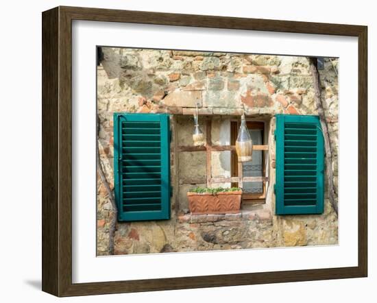 Italy, Chianti, Monteriggioni. Barred window with shutters, wine bottles and planter.-Julie Eggers-Framed Photographic Print