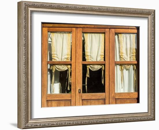 Italy, Tuscany, Monticchiello. Yellow curtains hanging in a window of a shop.-Julie Eggers-Framed Photographic Print