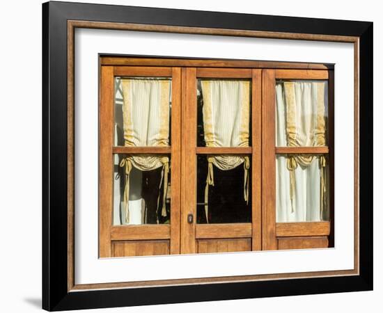 Italy, Tuscany, Monticchiello. Yellow curtains hanging in a window of a shop.-Julie Eggers-Framed Photographic Print