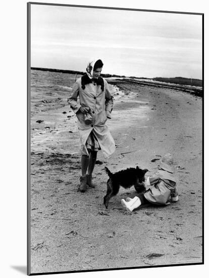 Jackie Kennedy, Wife of Sen, Walking Along Beach with Her Slicker Clad Daughter Caroline-Alfred Eisenstaedt-Mounted Photographic Print