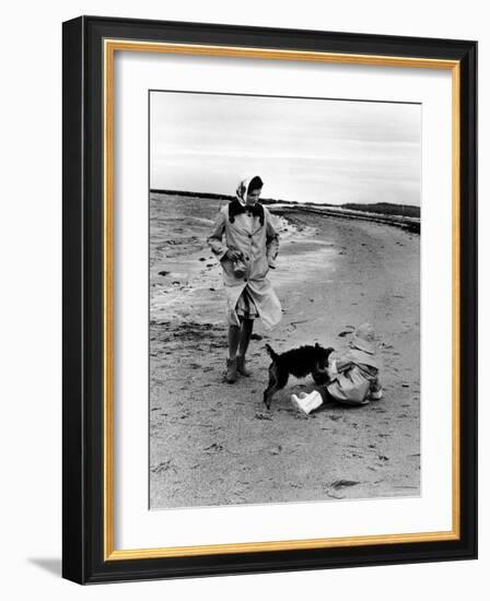 Jackie Kennedy, Wife of Sen, Walking Along Beach with Her Slicker Clad Daughter Caroline-Alfred Eisenstaedt-Framed Photographic Print