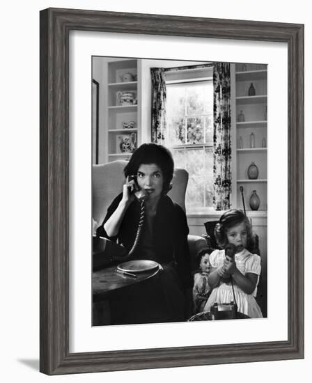 Jackie Kennedy, Wife of Senator John Kennedy, Talking on the Telephone as her daughter mimics her-Alfred Eisenstaedt-Framed Photographic Print