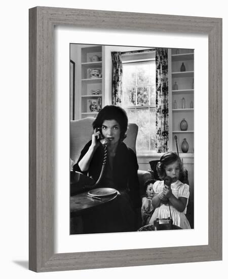 Jackie Kennedy, Wife of Senator John Kennedy, Talking on the Telephone as her daughter mimics her-Alfred Eisenstaedt-Framed Photographic Print