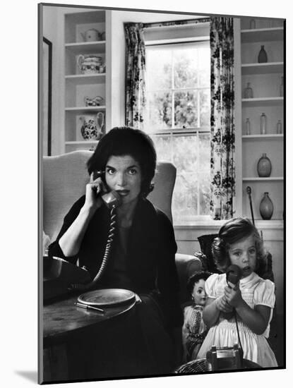 Jackie Kennedy, Wife of Senator John Kennedy, Talking on the Telephone as her daughter mimics her-Alfred Eisenstaedt-Mounted Photographic Print
