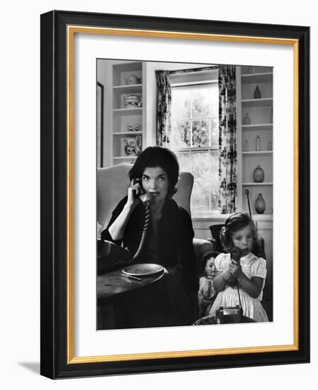 Jackie Kennedy, Wife of Senator John Kennedy, Talking on the Telephone as her daughter mimics her-Alfred Eisenstaedt-Framed Photographic Print