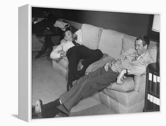 James Stewart Stretched Out on Office Sofa, Smiling, Producer Leland Hayward Slouches at Other End-John Florea-Framed Premier Image Canvas