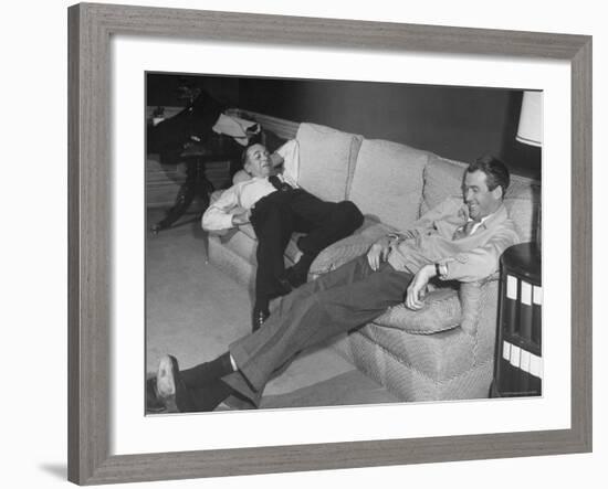 James Stewart Stretched Out on Office Sofa, Smiling, Producer Leland Hayward Slouches at Other End-John Florea-Framed Premium Photographic Print