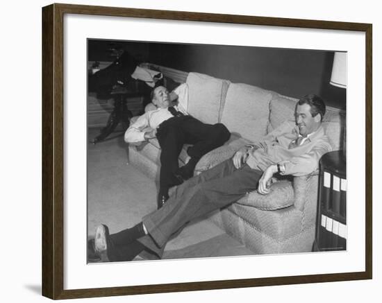 James Stewart Stretched Out on Office Sofa, Smiling, Producer Leland Hayward Slouches at Other End-John Florea-Framed Premium Photographic Print