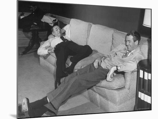James Stewart Stretched Out on Office Sofa, Smiling, Producer Leland Hayward Slouches at Other End-John Florea-Mounted Premium Photographic Print