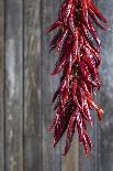 Dried Chillipods Hang Infront of Wooden Wall with Culinary Utensils-Jana Ihle-Photographic Print