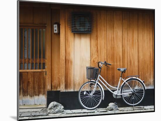 Japan, Chubu Region, Kyoto, Gion, a Bicycle Rests Against the Wall of a Traditional Building-Nick Ledger-Mounted Photographic Print