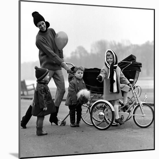 Jenny Boyd in Light Pants and Boots with Children, 1960s-John French-Mounted Giclee Print