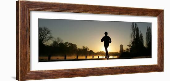 Jogger Silhouetted Against the Rising Sun as He Runs Past the Serpentine Lake in Hyde Park, London-null-Framed Photographic Print