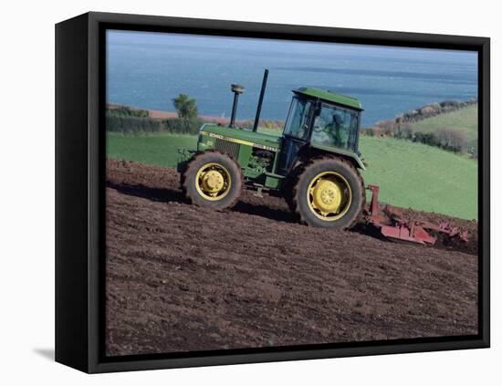 John Deere Tractor with a Rotivator on a Sloping Field in Spring, at Holcombe, Devon, England, UK-Ian Griffiths-Framed Premier Image Canvas