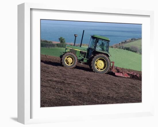 John Deere Tractor with a Rotivator on a Sloping Field in Spring, at Holcombe, Devon, England, UK-Ian Griffiths-Framed Photographic Print