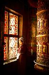 A Tibetan woman stands next to a large prayer wheel of the temple of Boudhanath Stupa, Kathmandu, N-Julian Bound-Mounted Photographic Print