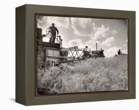 Kansas Farmer Driving Farmall Tractor as He Pulls a Manned Combine During Wheat Harvest-Margaret Bourke-White-Framed Premier Image Canvas
