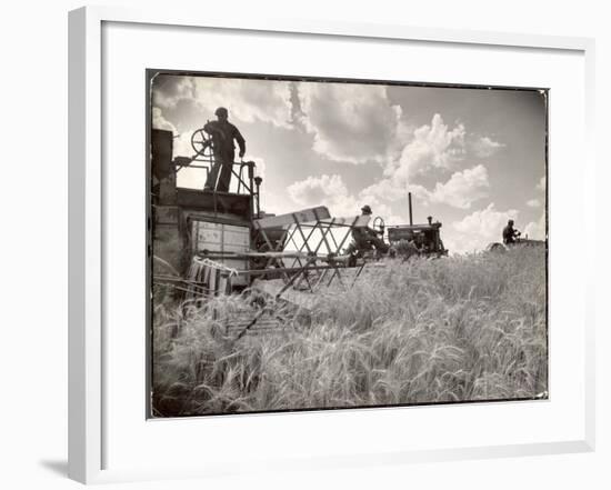 Kansas Farmer Driving Farmall Tractor as He Pulls a Manned Combine During Wheat Harvest-Margaret Bourke-White-Framed Premium Photographic Print