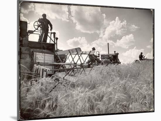 Kansas Farmer Driving Farmall Tractor as He Pulls a Manned Combine During Wheat Harvest-Margaret Bourke-White-Mounted Premium Photographic Print